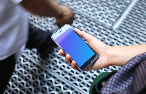 Woman holding iPhone 6s mockup on a bridge