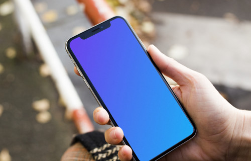 Woman sitting and holding iPhone X mockup