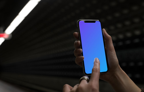 Woman with iPhone X mockup in underground station