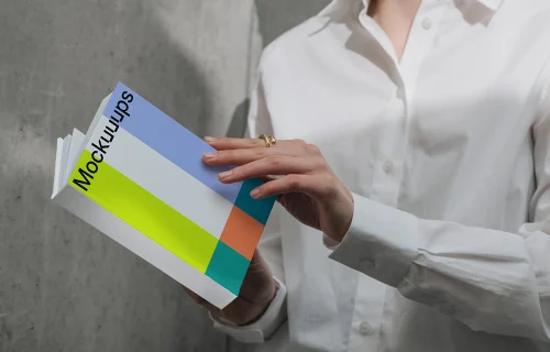 A-format book mockup held by person in white shirt