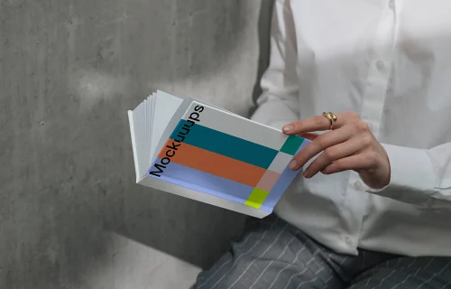 A-format book mockup in hands against concrete wall