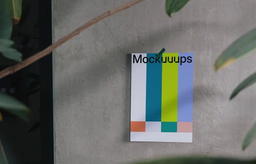 A4 poster mockup with plants on a concrete wall