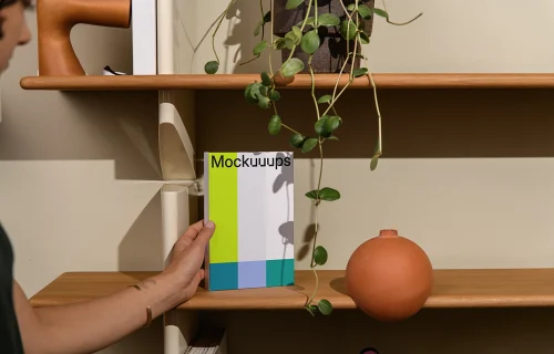 B-format book mockup on a wooden shelf with decor