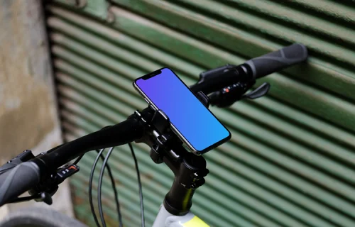 Bike leaned against a garage with iPhone 11 Pro mockup in bike mount