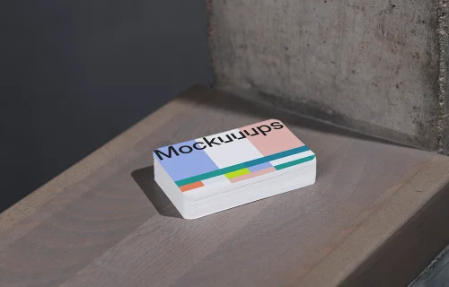 Business card mockup on wooden surface near concrete wall