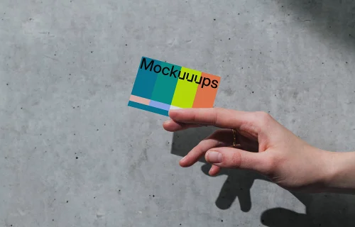 Business card mockup with hand on concrete background