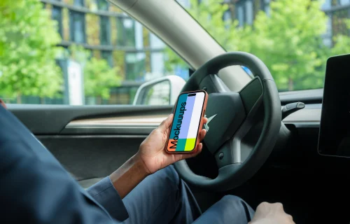 Businesswoman thriving in Tesla with iPhone 14 Pro