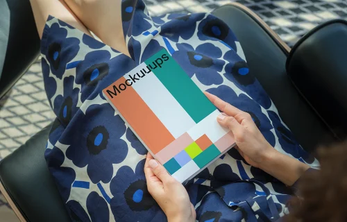 C-format book mockup held by a seated person