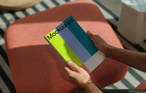 C-format book mockup in hands on a modern stool