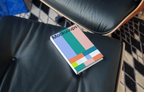 C-format book mockup on a leather chair in a modern setting