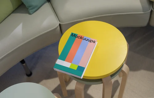 C-format book mockup on colorful round tables in a cozy living area