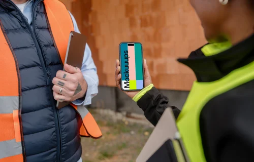 Construction engineer holding an iPhone mockup