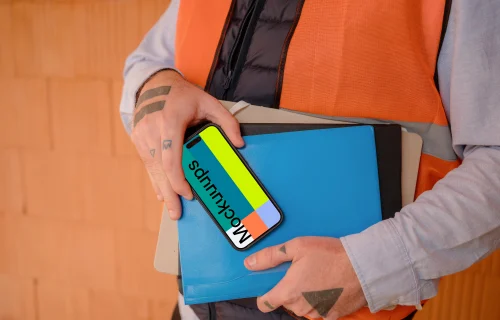 Construction worker presenting an iPhone 15 Pro mockup