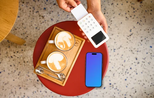 Cozy cafe setting with payment terminal and an iPhone mockup