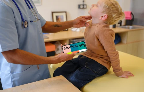 Doctor holding an iPhone mockup next to the child