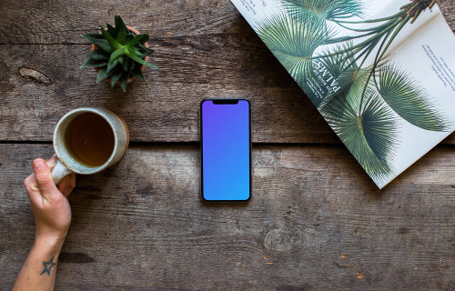 Drinking tea over the iPhone XS mockup and plants