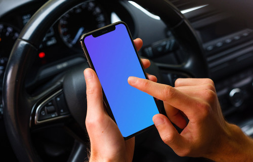 Driver tapping iPhone 11 mockup in front of steering wheel
