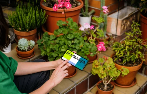 Female hand typing on a Google Pixel mockup in garden