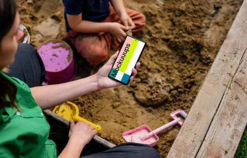 Female holding a Google Pixel in sandpit mockup