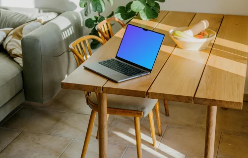 Grey MacBook Pro mockup at the edge of a table