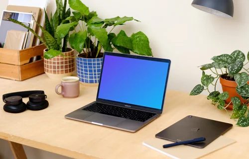 Grey MacBook Pro on a table with plants in the background