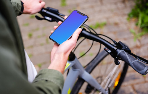 Holding an iPhone 11 Pro mockup while waiting on a bike