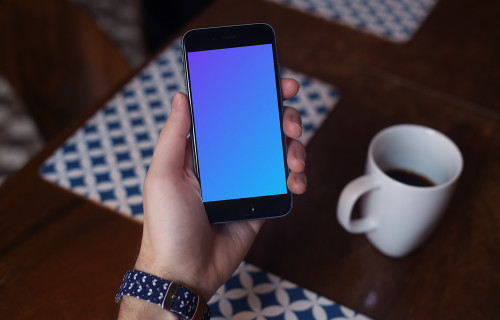 Holding iPhone 6 mockup and drinking coffee