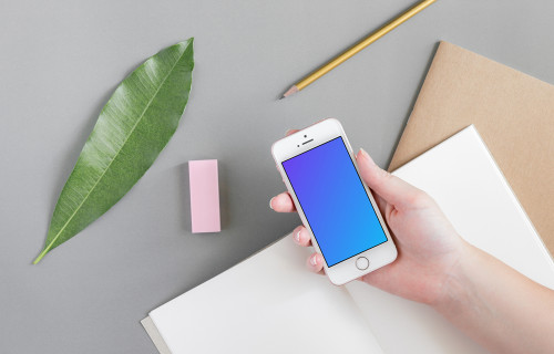 Holding iPhone SE mockup over the journal