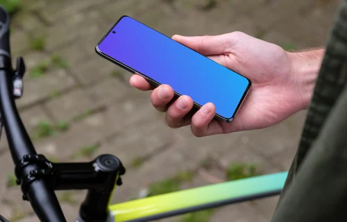 Holding Samsung S20 mockup in one hand next to a bike