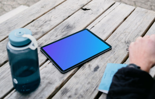 iPad Air mockup on a table with a bottle at the side