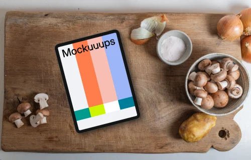 iPad and mushrooms on a wooden chopping board