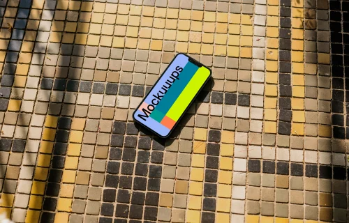 iPhone 13 mockup on a colorful garden paving