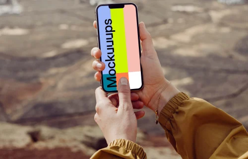 iPhone 13 Pro mockup held with both hands by a user outdoors