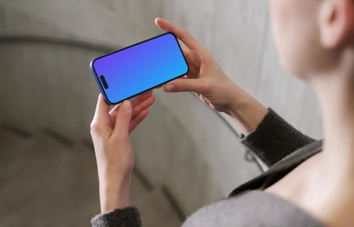 iPhone 16 mockup in a hand against concrete backdrop