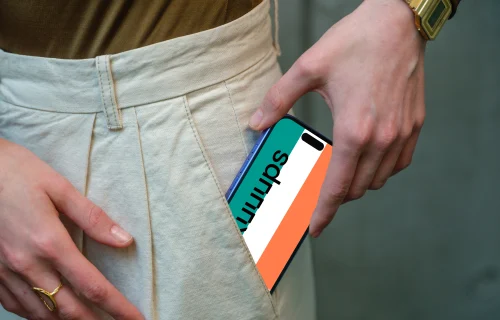 iPhone 16 mockup in hand with casual outfit