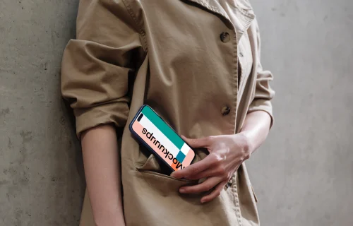 iPhone 16 mockup in woman's hand on concrete background