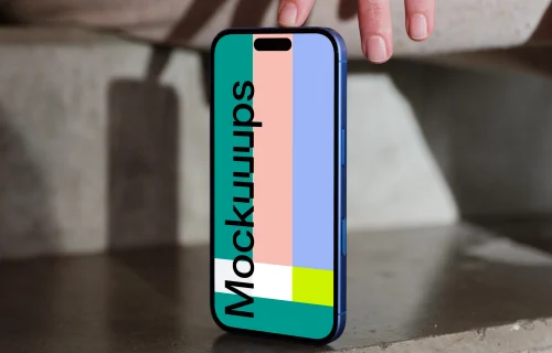 iPhone 16 mockup on a concrete surface with hand detail