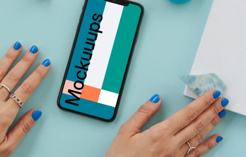  iPhone mockup on a blue table beside a pair of earbuds