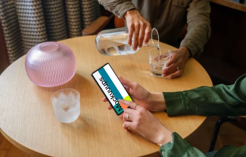 Lounge setting and woman working on a Google Pixel mockup