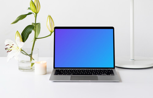 MacBook mockup on a white table with white table lamp at the side