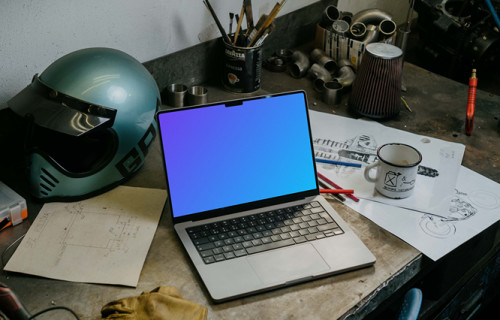 MacBook Pro mockup beside a motorcylce helmet