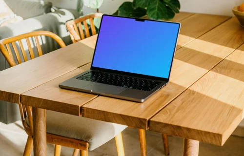 Free MacBook Pro mockup on a table with a plant in the background