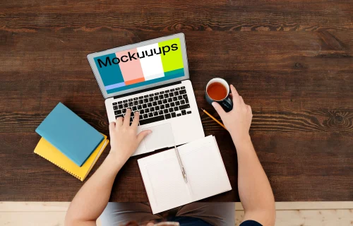 Man holding a coffee and using MacBook Air mockup