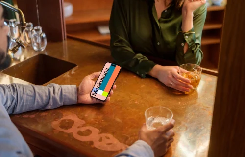 Man holding a iPhone mockup in the lounge
