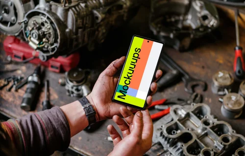 Man holding Pixel 6 mockup in a mechanic shop