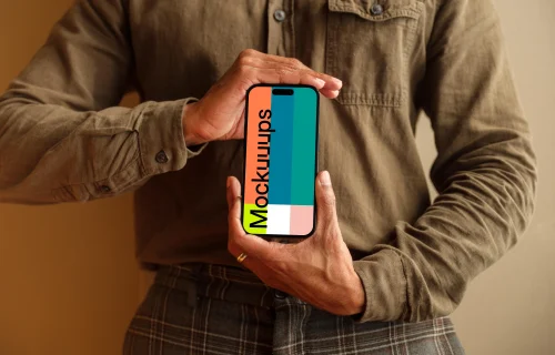 Free mockup of man in khaki shirt holding the iPhone