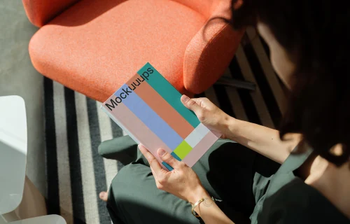 Mockup of a book held in hands with a modern interior background