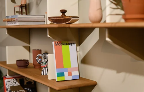 Mockup of a C-format book on a wooden shelf with decor