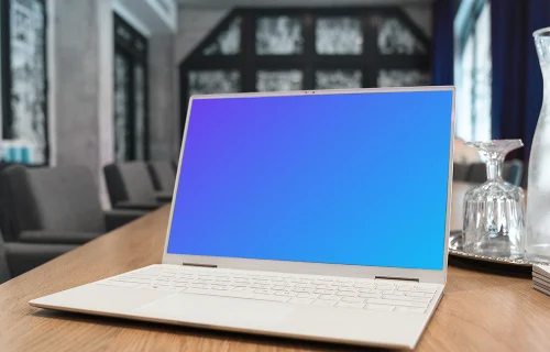 White Dell XPS Mockup on a table with wine glasses at the side