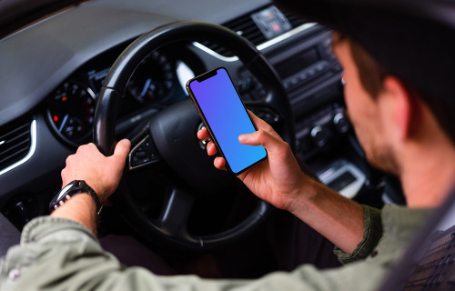 Over the shoulder view of driver tapping iPhone 11 mockup